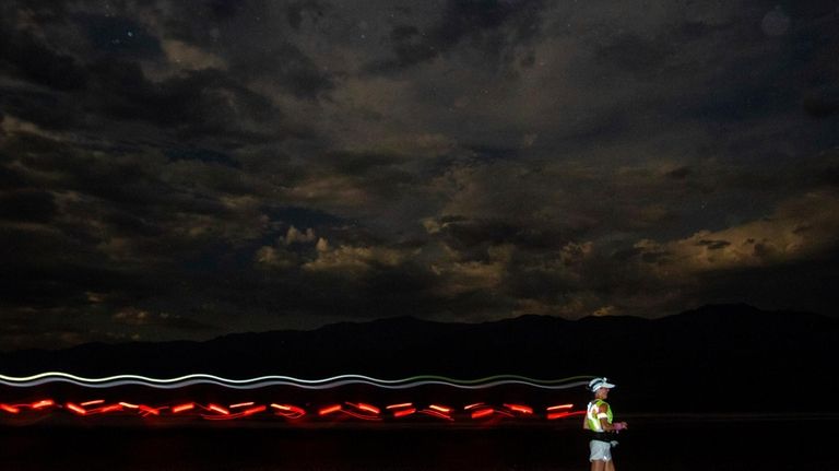 A runner races with a headlamp and a safety vest...