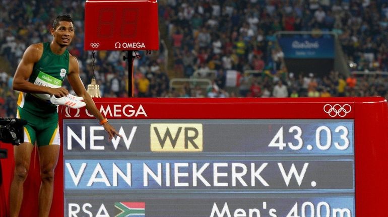 Wayde van Niekerk of South Africa celebrates placing first in...