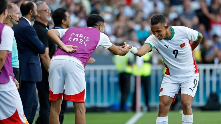 Morocco's Soufiane Rahimi, right, celebrates after scoring his side's fourth...