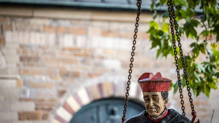 The sculpture of Cardinal Franz Hengsbach hangs on the chains...
