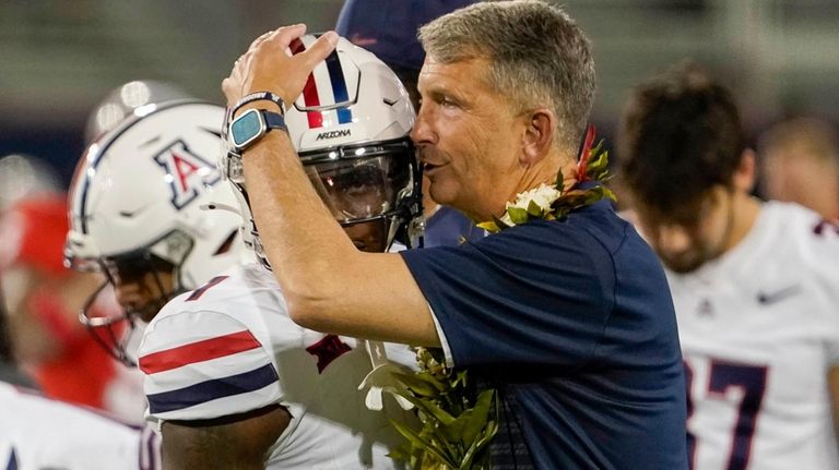 Arizona's first year head coach Brent Brennan hugs his running...