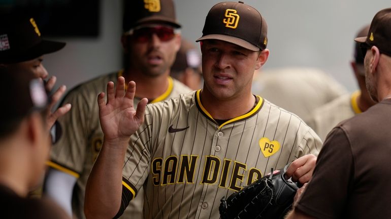 San Diego Padres pitcher Michael King is greeted in the...