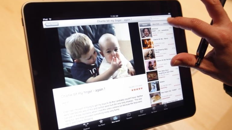 The Apple iPad is examined after its unveiling at the...