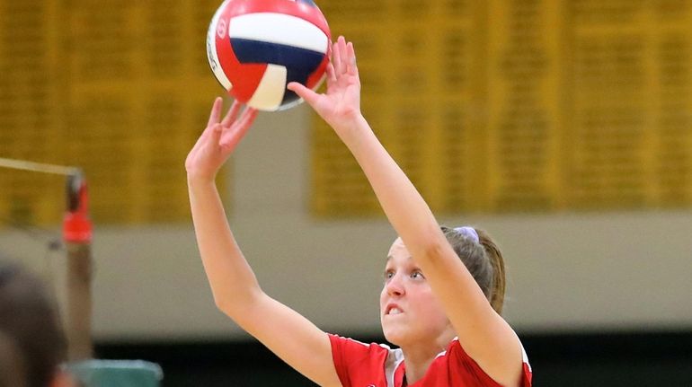 Patchogue-Medford's Caitlin Dellecave sets the ball at the net in...