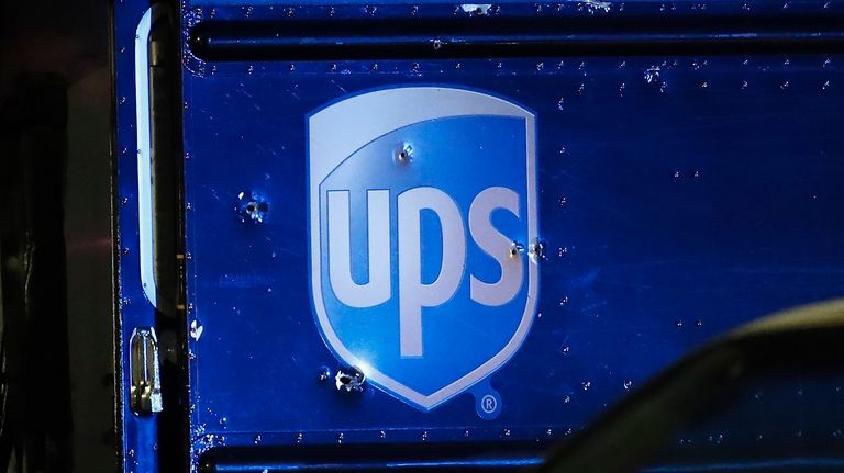 FILE- Bullet holes are seen around the UPS logo of...