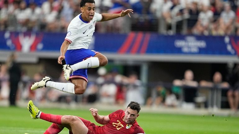 Tyler Adams of the United States jumps over Bolivia's Fernando...