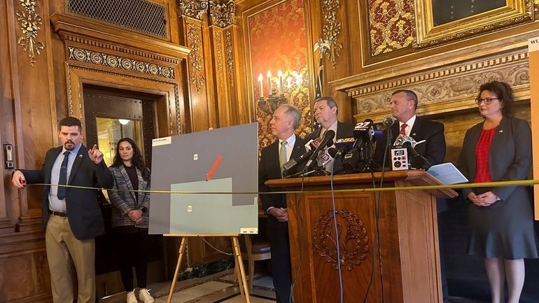 Wisconsin Republican Rep. Nate Gustafson holds a tape measure in...