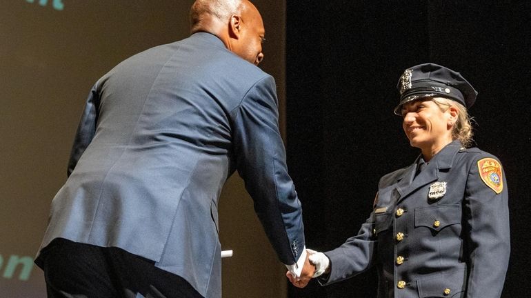 Graduate Diana D'Angio on stage with Suffolk County Police Commissioner Rodney...