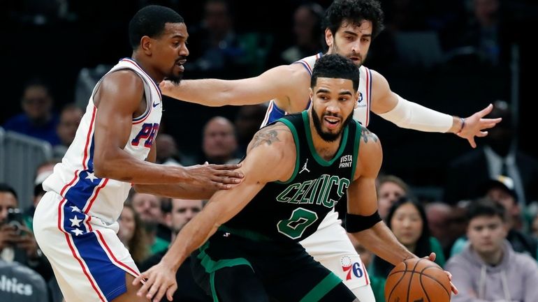 Boston Celtics' Jayson Tatum (0) keeps the ball away from...