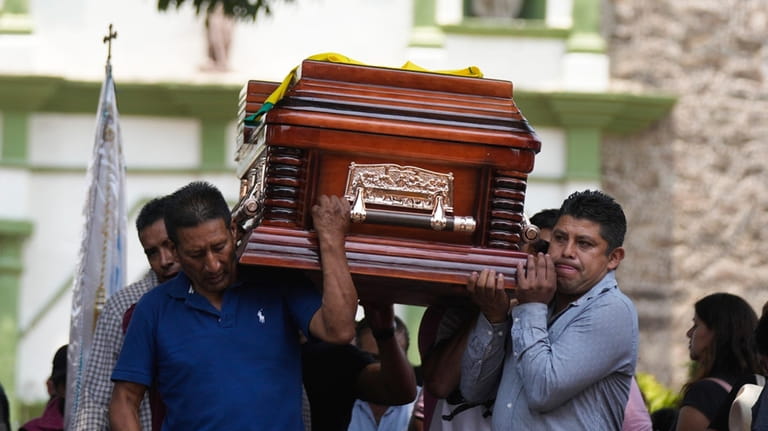 Relatives and friends carry the coffin that contain the remains...