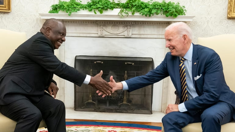 President Joe Biden shakes hands with South African President Cyril...
