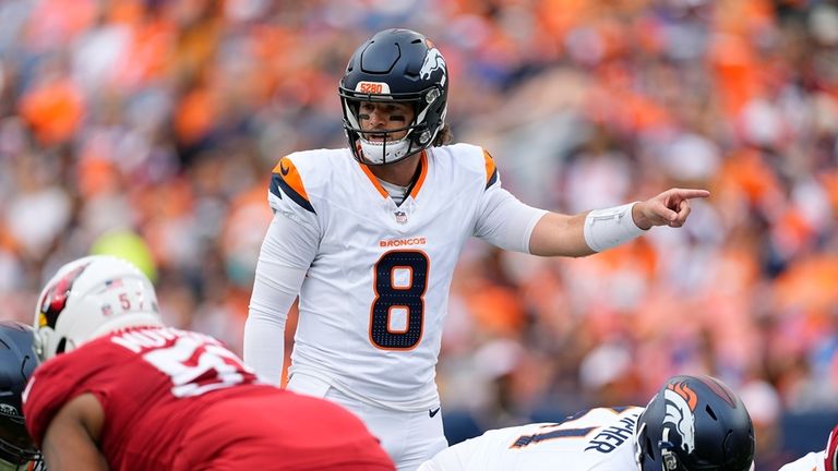 Denver Broncos quarterback Jarrett Stidham signals to his players during...