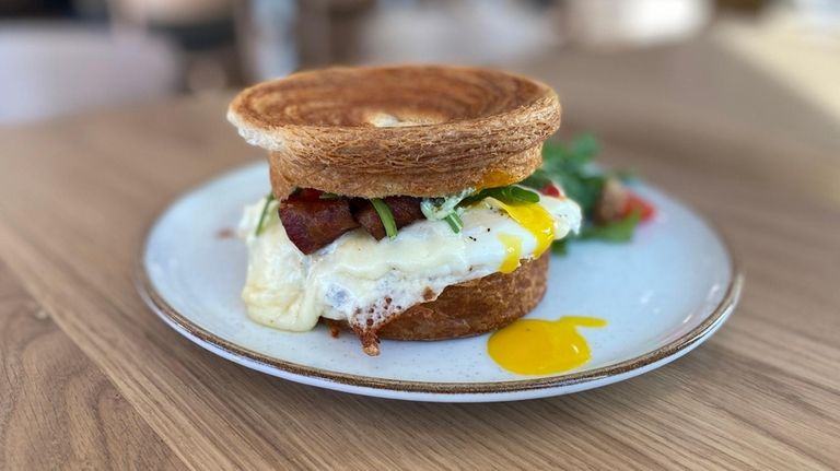 Croissant "suprême" sandwich with bacon, eggs, cheese and basil aioli,...