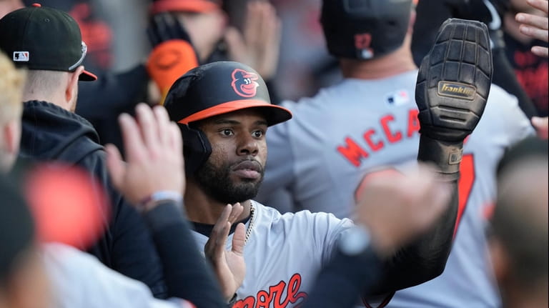 Baltimore Orioles' Cedric Mullins celebrates in the dugout after scoring...