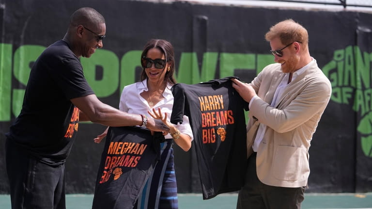 Masai Ujiri, Toronto Raptors President, left, presents T-Shirts to Prince...