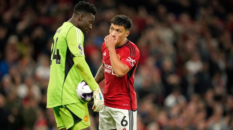Manchester United's Lisandro Martinez talks with Manchester United's goalkeeper Andre...