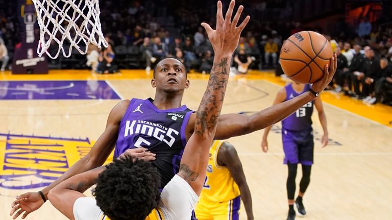 Sacramento Kings guard De'Aaron Fox, top, shoots as Los Angeles...