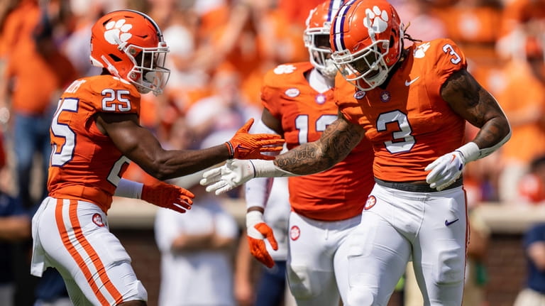 Clemson safety Jalyn Phillips (25) celebrates with defensive end Xavier...