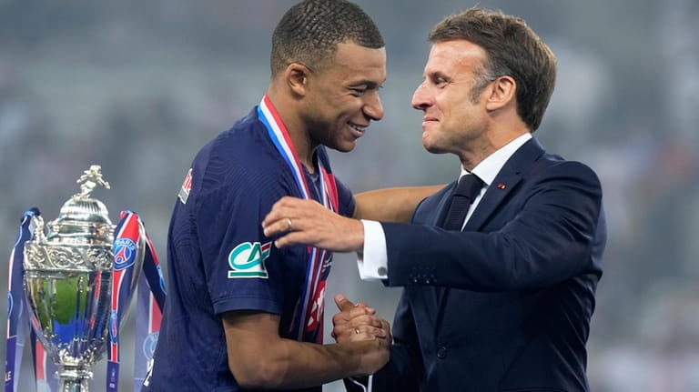 French President Emmanuel Macron greets PSG's Kylian Mbappe during the...