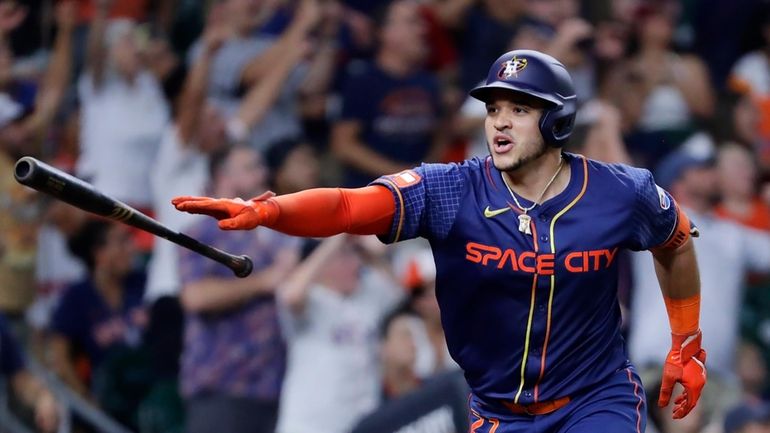 Houston Astros' Yainer Diaz flips his his bat after hitting...