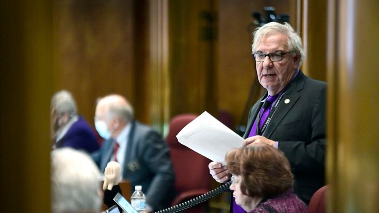 North Dakota Sen. Ray Holmberg, R-Grand Forks, goes through the...