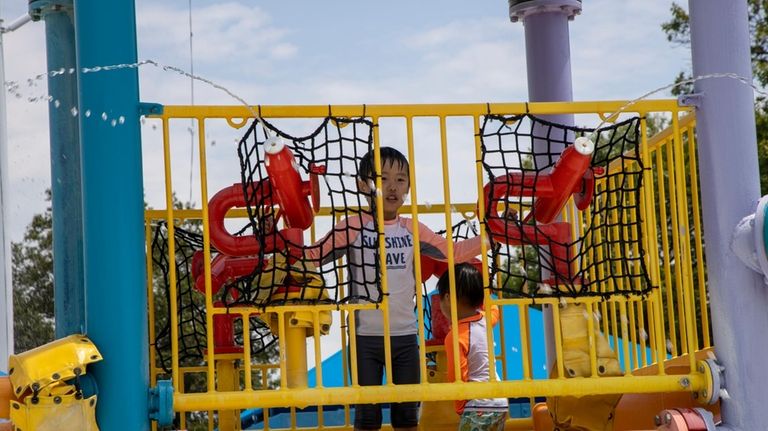 Nathan Ban, of Old Westbury, enjoys the splash park at...