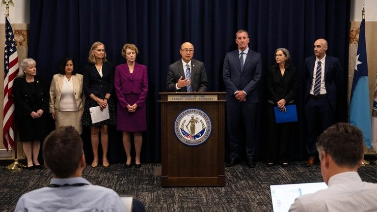 Ramsey County Attorney John Choi, center, discusses his office's review...