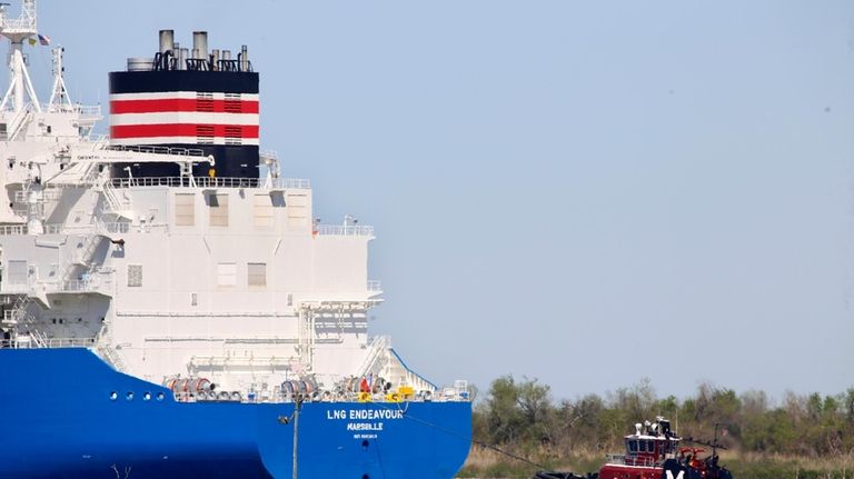 File - A tugboat helps guide a French ship, the...