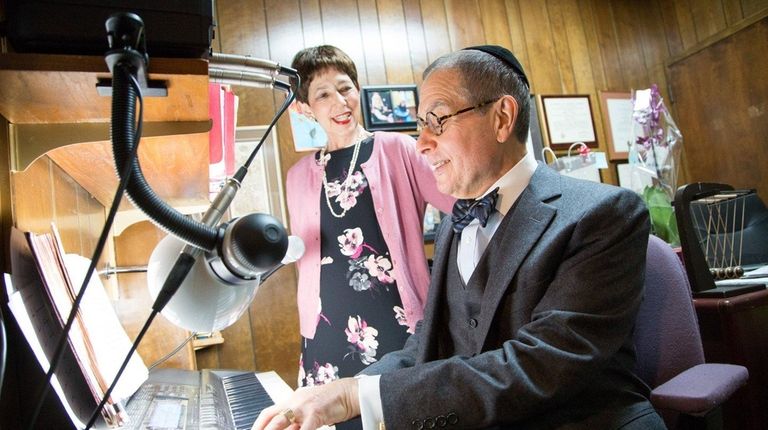 Morris Wolk plays a keyboard in his study. With him...