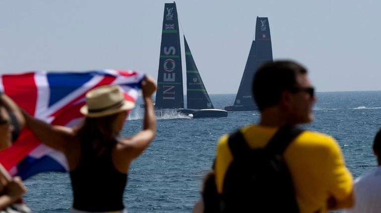 Spectators watch the race between Ineos Britannia's AC75 and Alinghi...