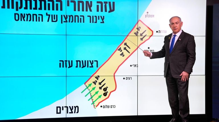 Israeli Prime Minister Benjamin Netanyahu stands before a map of...