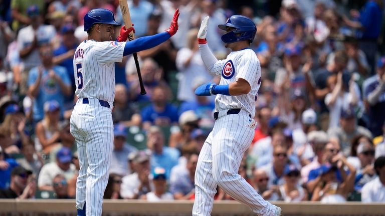 Chicago Cubs' Seiya Suzuki, right, high-fives designated hitter Christopher Morel...