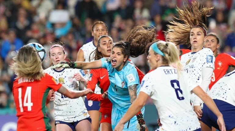 Portugal goalkeeper Ines Pereira, centre, punches the ball clear during...