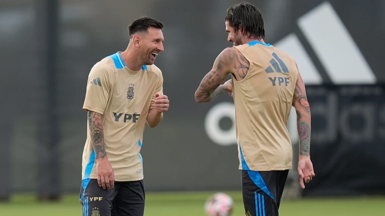 Lionel Messi, left, laughs with Rodrigo De Paul as members...