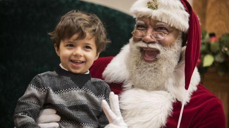 Larry Jefferson, playing the role of Santa, poses with Jack...