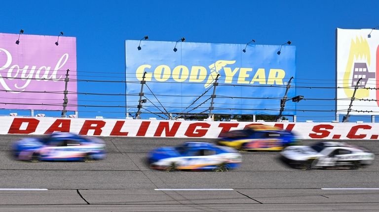 A pack of cars compete through Turn 1 during a...