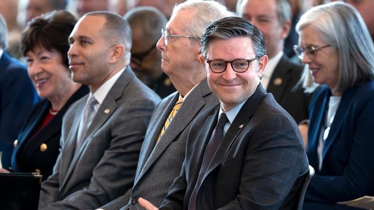 Speaker of the House Mike Johnson, R-La., right, smiles as...