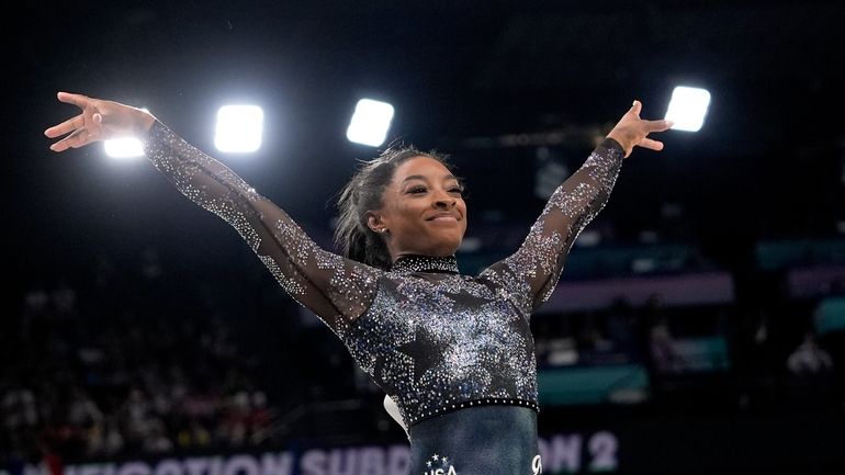 Simone Biles, of United States, smiles after competing on the...