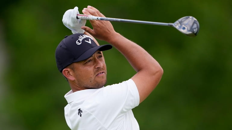 Xander Schauffele watches his tee shot on the fourth hole...