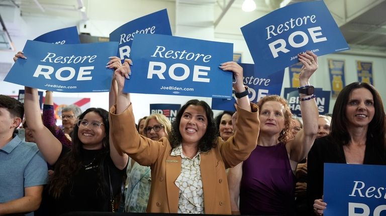 People listen as President Joe Biden speaks about reproductive freedom...