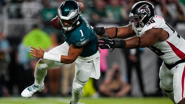 Philadelphia Eagles quarterback Jalen Hurts (1) runs past Atlanta Falcons...