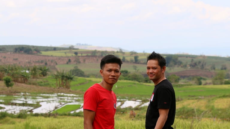 Joemar Flores, and his neighbor, Junthan Giumba pose for a...