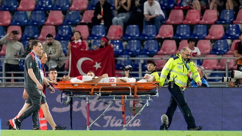 Turkey's Ozan Kabak is carried injured out of the pitch...