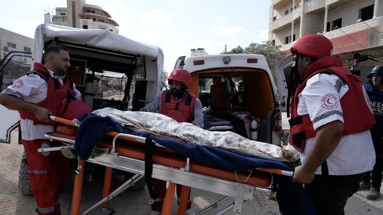 Paramedics carry the body of Ayed Abu Al-Hija, 64, a...