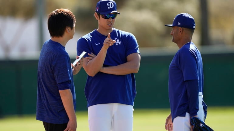 Los Angeles Dodgers' Shohei Ohtani, center, with interpreter Ippei Mizuhara,...