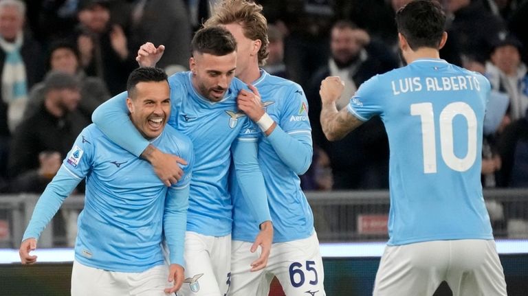 Lazio's Pedro, left, celebrates with his teammates after he scored...