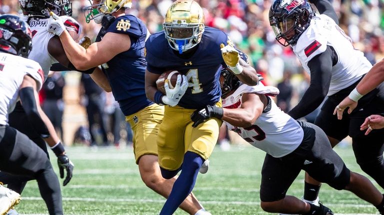 Notre Dame running back Jeremiyah Love (4) tries to break...