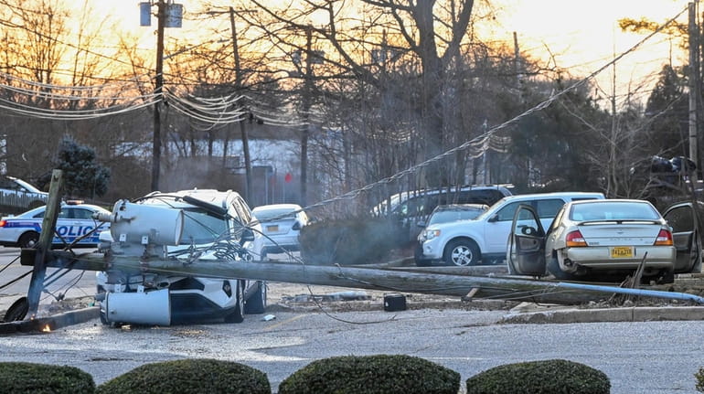 A Nissan Maxima, right, crashed into a utility pole, which...