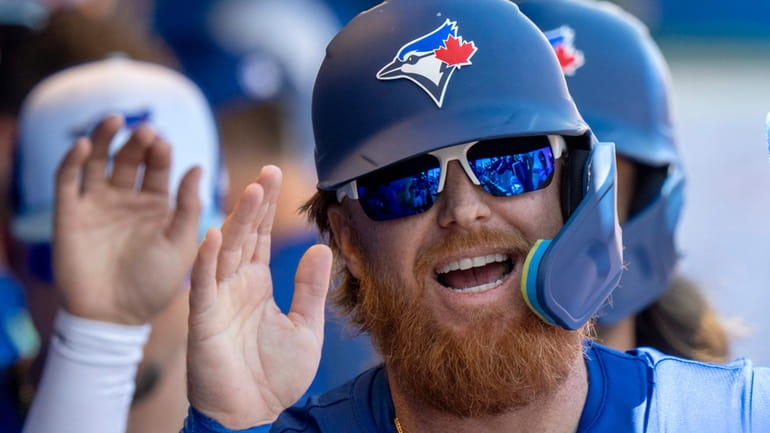 Toronto Blue Jays Justin Turner smiles as he is congratulated...