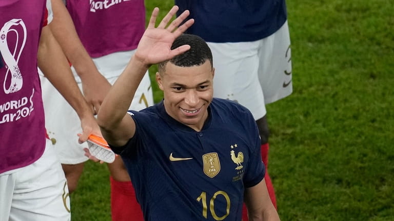 France's Kylian Mbappe waves his hand at the end of...